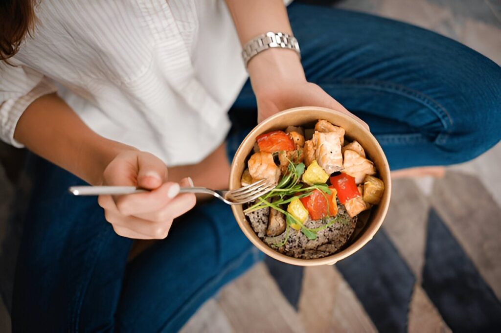 A person holding a bowl of food