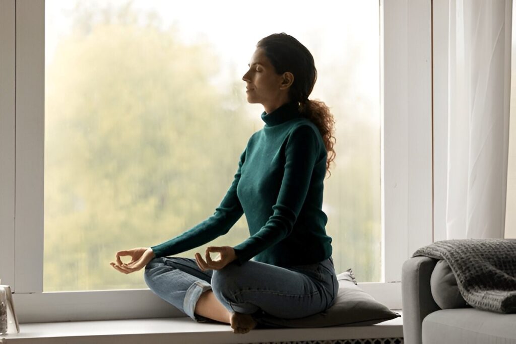 Woman meditating by a window