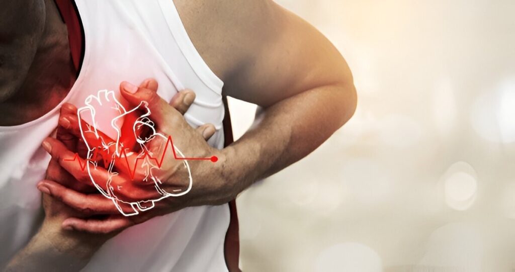 Person clutching chest in pain, indicating a heart attack or cardiovascular issue.
