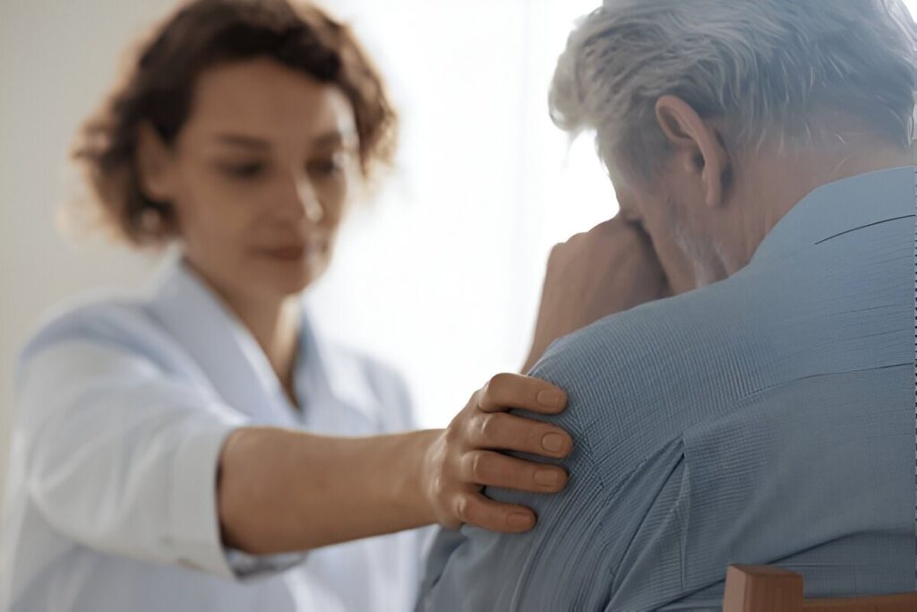 Woman comforting a distressed older man.