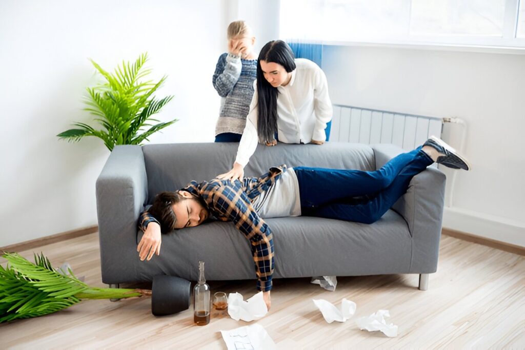 A person lying on a couch with a person standing behind him